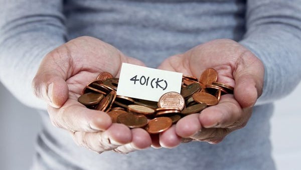 Hands holding pennies and a sign that reads 401(K)