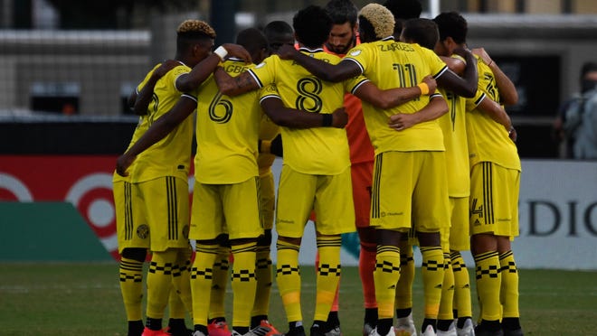 Crew starters huddle up prior to a game against Atlanta United on July 21 in the MLS is Back tournament. The Crew outscored its opponents by a combined 7-0 in the group stage.