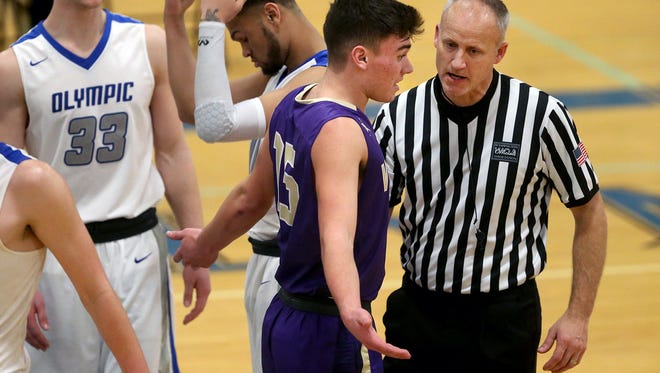 North Kitsap player Ryan Hecker explains the on court chatter to referee Mark Knowles Friday night at Olympic.