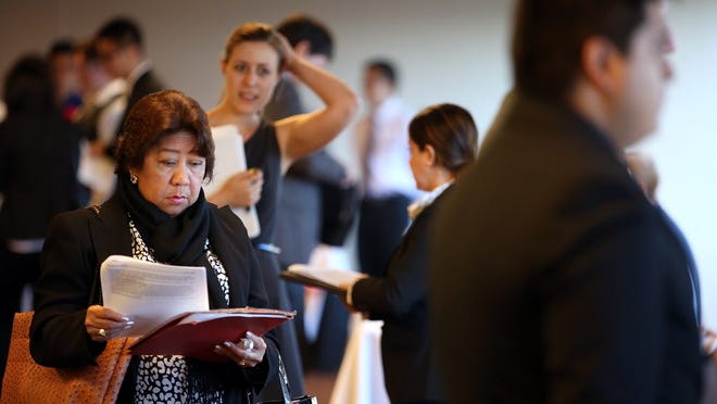 Job seekers wait in line to meet with recruiters in San Francisco on June 4.