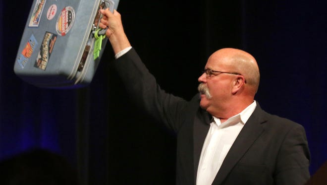 Former House Speaker John Gregg, who ran unsuccessfully for governor in 2012, held up what he joked was Gov. Mike Pence's suitcase and said the Republican is spending more time on the road exploring a bid for national office than he is doing his job in Indiana. Gregg spoke at the Indiana Democratic Convention on Saturday in Indianapolis. Photo by Lesley Weidenbener, TheStatehouseFile.com