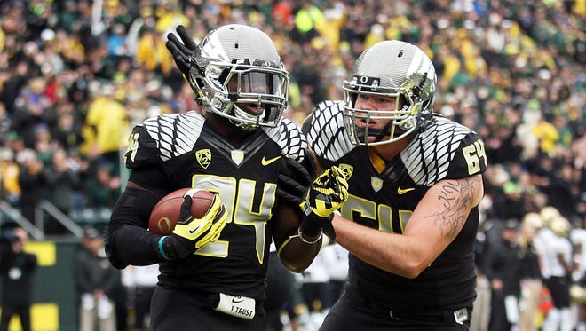 Tyler Johnstone congratulates Kenjon Barner on the game's first touchdown as the Oregon Ducks host the Colorado Buffaloes at Autzen Stadium in Eugene in a Pac-12 college football battle.