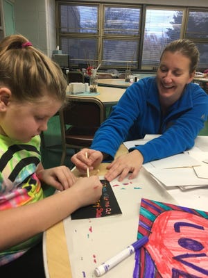 A Right At School employee helps a Oak Hills student during the after school enrichment program.