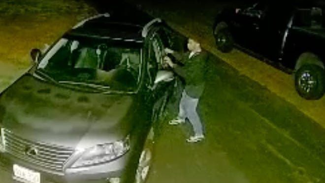 This image from a Ring video shows a man attempting to open the door of a vehicle parked in a Millis driveway.