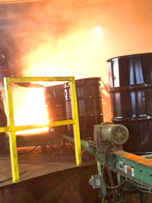 A flame plume wraps around a barrel as a chemical drum is dumped into a burner. This image, taken in late September 2013, is from a 2013 audit of Drumco of Arkansas in Arkadelphia, Ark.