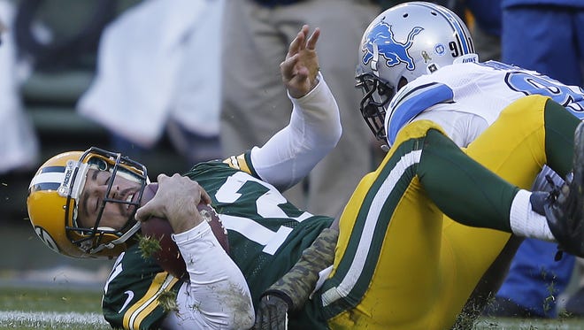 Green Bay Packers quarterback Aaron Rodgers (12) is tackled on a scramble by Detroit Lions defensive end Jason Jones (91) against the Detroit Lions at Lambeau Field November 15, 2015.