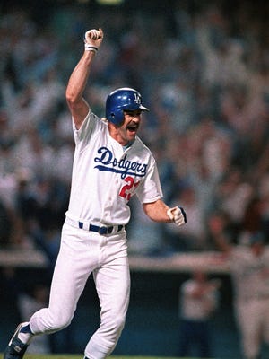 Kirk Gibson celebrates as he rounds the bases after hitting a game-winning two-run home run in the bottom of the ninth inning to defeat the Athletics in Game 1 of the World Series.