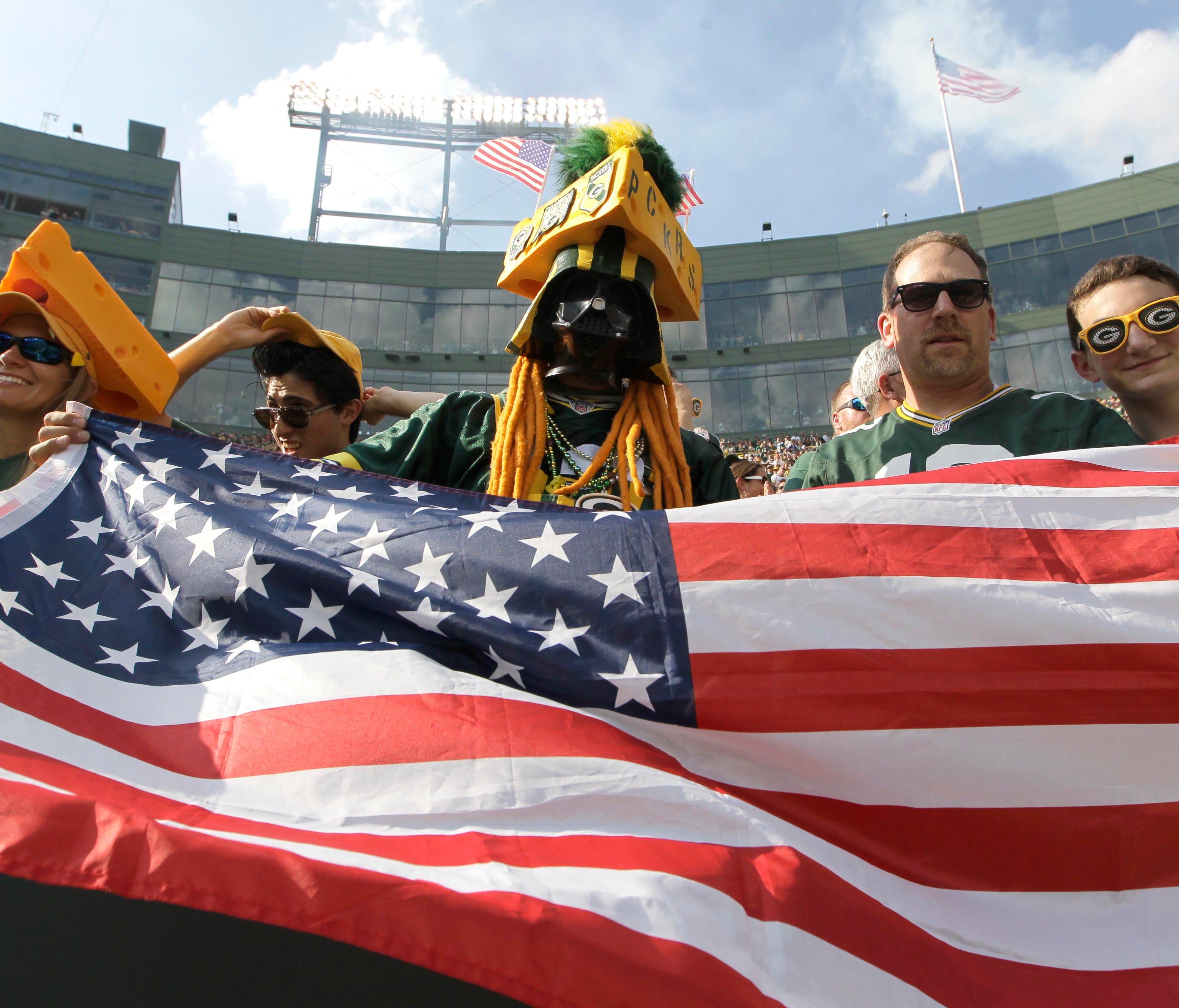 Green Bay Packers fans wave the American flag following the national anthem on Sunday.