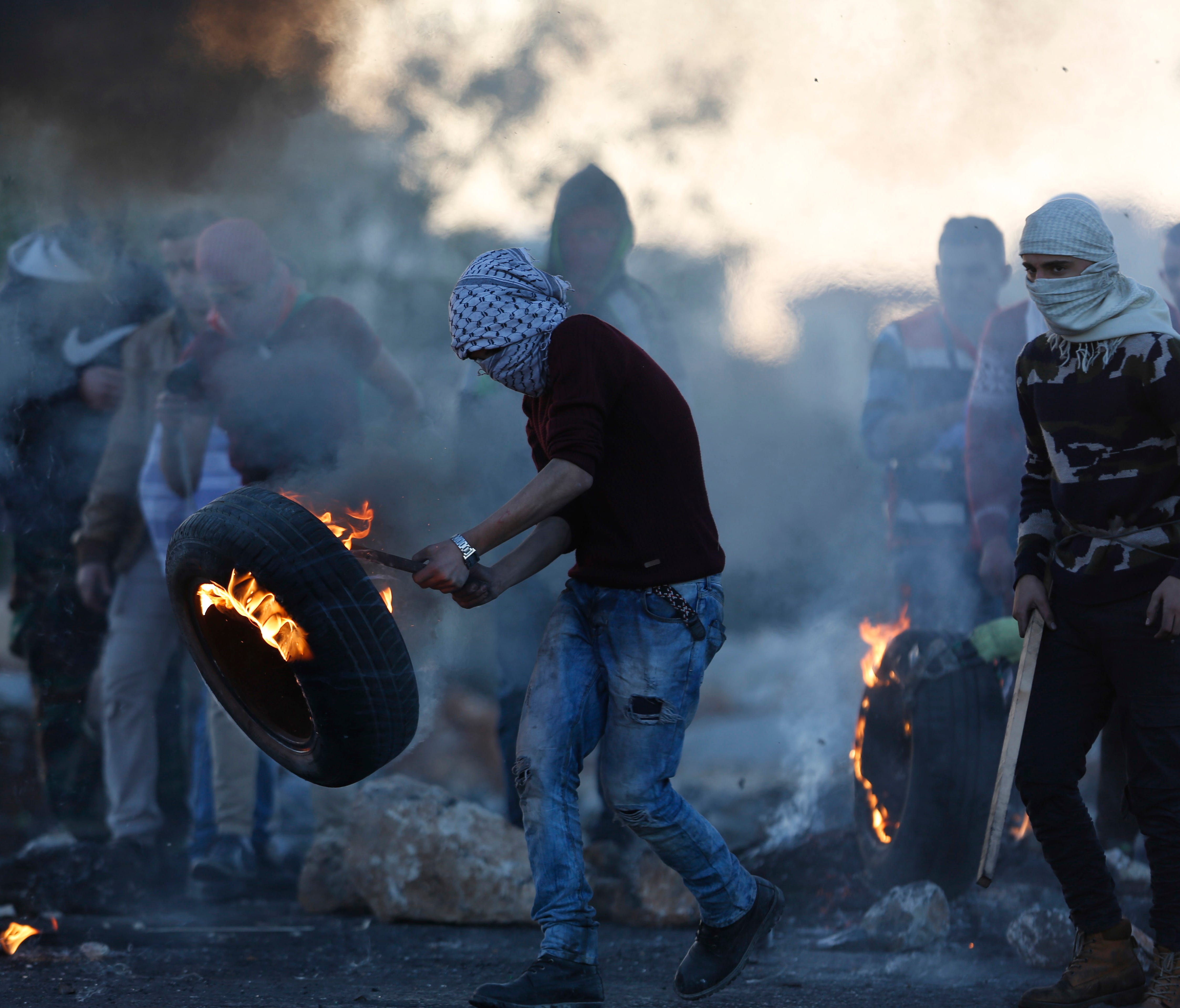 Palestinians burn tires during protests against U.S. President Donald Trump's decision to recognize Jerusalem as the capital of Israel in the West Bank town of Ramallah on Dec. 16, 2017.