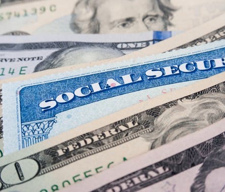 A Social Security card inserted in a pile of money.
