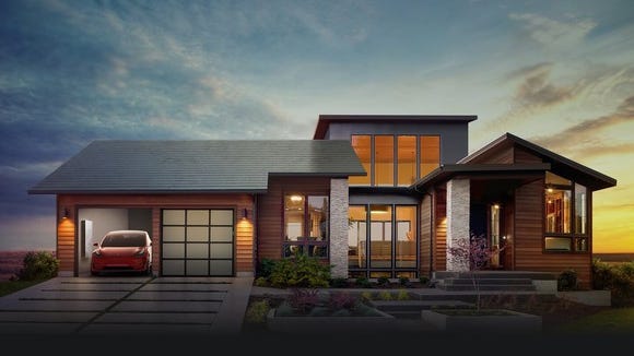 Home with a solar roof and a Tesla in the garage.