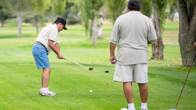 Participants tee off during the 2015 alumni golf tourney.