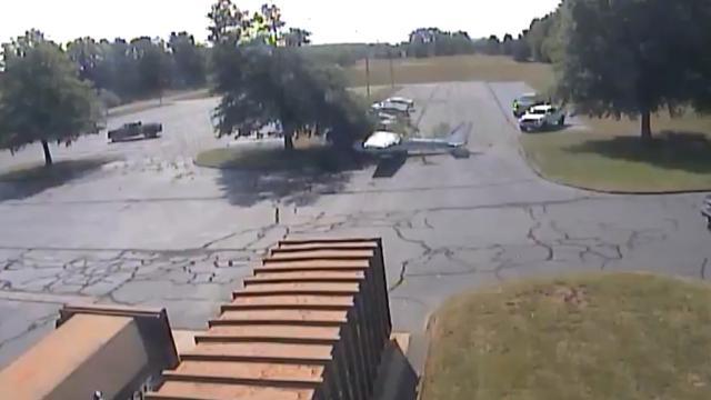 Plane crashes into tree, flips into parking lot