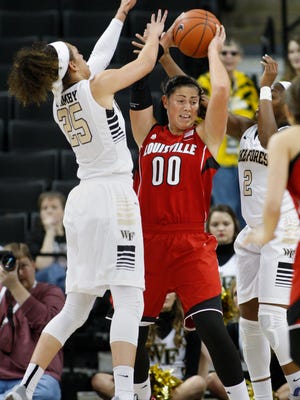 Louisville forward Sara Hammond (00) looks to pass out of a double-team by Wake Forest forward Dearica Hamby, left, and guard Amber Campbell during the first half of an NCAA college basketball game in Winston-Salem, N.C., Sunday, Jan. 11, 2015. (AP Photo/Nell Redmond)