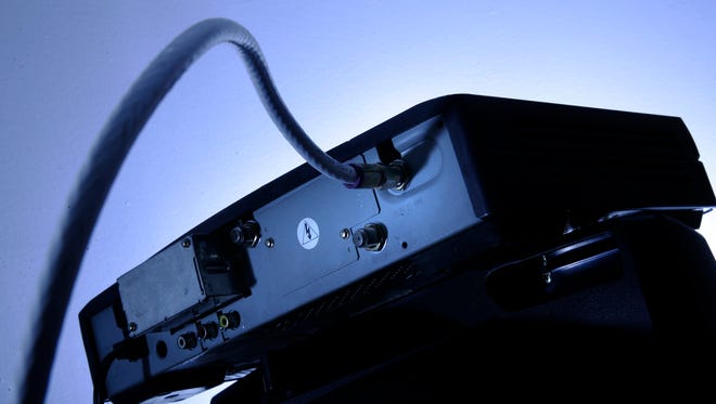 A cable box is mounted on top of a television.