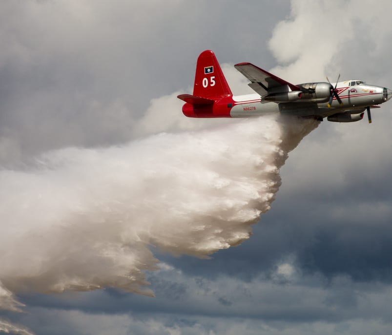 Tanker 05, a Lockheed P-2 Neptune fire tanker, makes a water drop at a farewell open house at the company's Missoula, Mont., headquarters on Oct. 1, 2017. The airplane was retired from Neptune's fleet after 24 years.