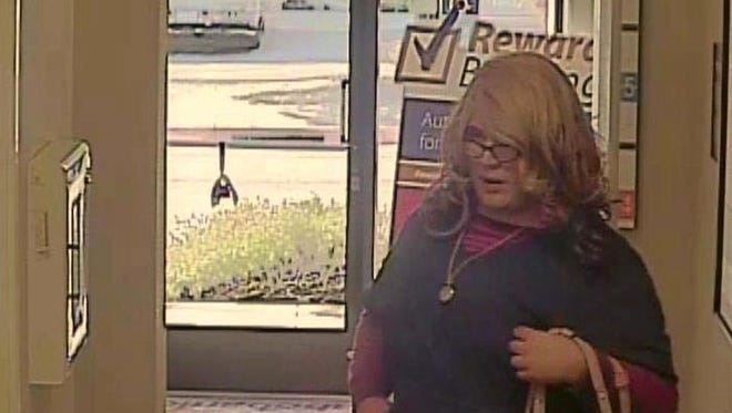 This Friday, April 3, 2015, image from surveillance video provided by the Santa Cruz Police Department shows a wanted man dubbed the "Mrs. Doubtfire" bandit because he was disguised as a woman during a bank robbery in Santa Cruz, Calif. He wore a wavy blonde wig, thick-framed glasses and navy blue hospital scrubs, and carried a purse. About an hour later the same man in the same outfit handed a teller a note that demanded money at a second US Bank branch in Santa Cruz. The suspect got away with an unknown amount of money.  (AP Photo/Santa Cruz Police Department)