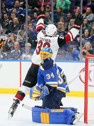 Arizona Coyotes right wing Christian Fischer, top, reacts after scoring against St. Louis Blues goaltender Jake Allen, bottom, in the second period of an NHL hockey game Saturday, Jan. 20, 2018, in St. Louis.