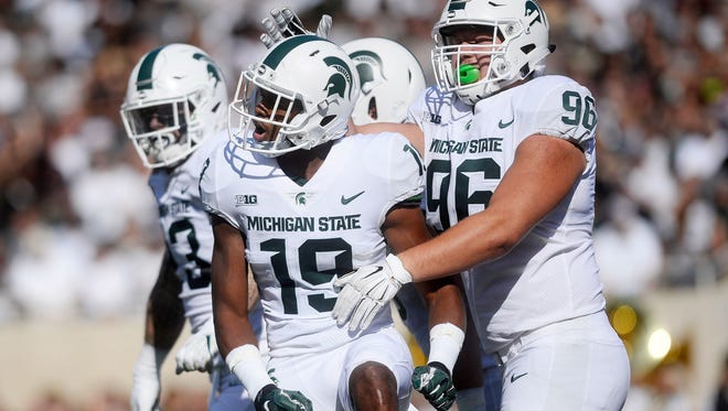 Michigan State's Josh Butler, left, celebrates his sack with teammate Jacub Panasiuk during the second quarter on Saturday, Sept. 9, 2017, at Spartan Stadium in East Lansing.