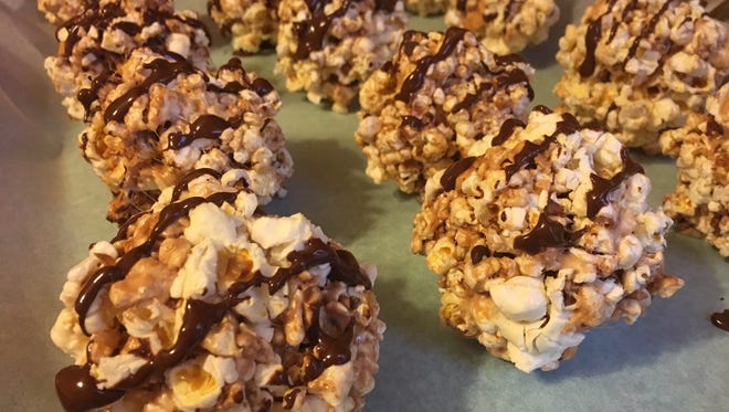 Popcorn balls are an easy and fun treat to bring to family holiday meals. These popcorn balls were made using marshmallows, miniature chocolate chips and butterschotch chips.
