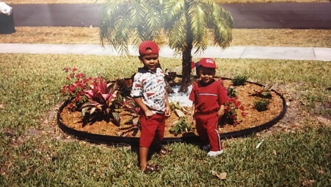 Miami defensive tackle (left) poses for a photo with little brother and Notre Dame running back Deon McIntosh (right) in their neighborhood in Pompano Beach, Fla. when they were kids.