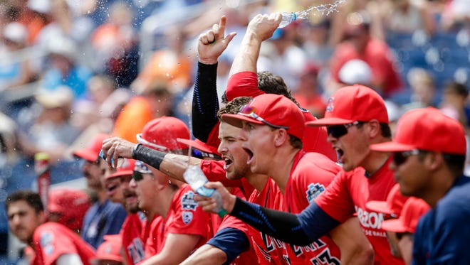 Arizona players celebrate in the dugout after Kyle Lewis scored a run against Oklahoma State on a double by Louis Boyd, during the second inning of an NCAA men's College World Series baseball game in Omaha, Neb., Saturday, June 25, 2016.