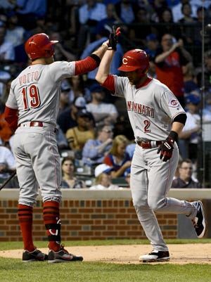 Cincinnati Reds shortstop Zack Cozart (2) high-fives Cincinnati Reds first baseman Joey Votto (19) after he hits a home run in the third inning against the Chicago Cubs at Wrigley Field on May 17.