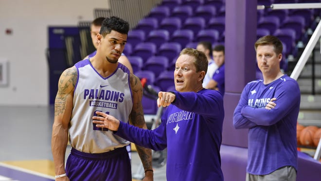 Furman's Kris Acox, left, receives instruction from basketball coach Niko Medved during practice Friday.