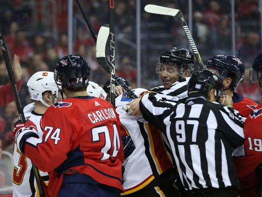 Nov. 20: Linesmen break up a scrum between the Flames