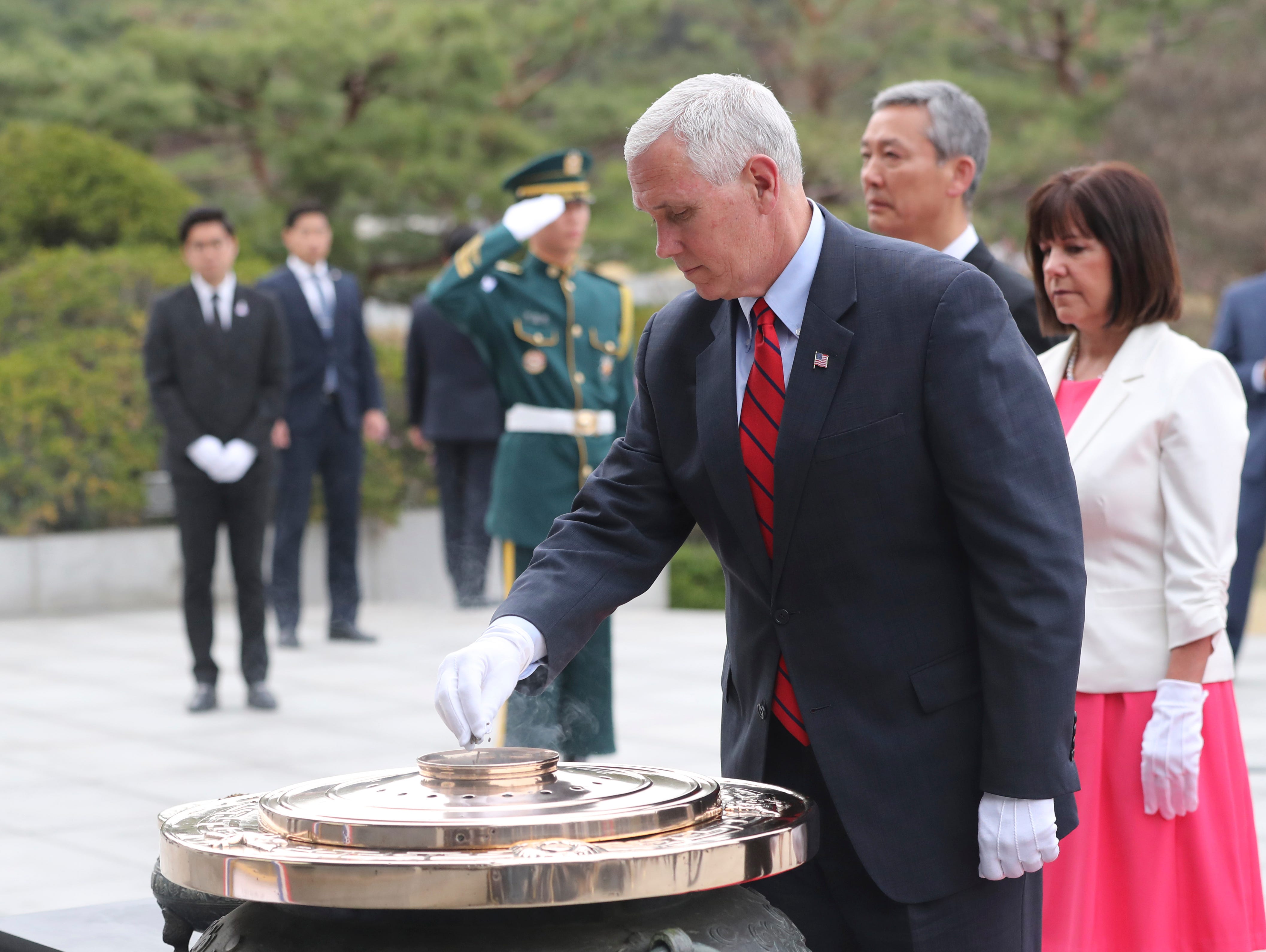 U.S. Vice President Mike Pence burns incense in front of his wife Karen Pence, right, at the Seoul National Cemetery in Seoul, South Korea, Sunday, April 16, 2017.