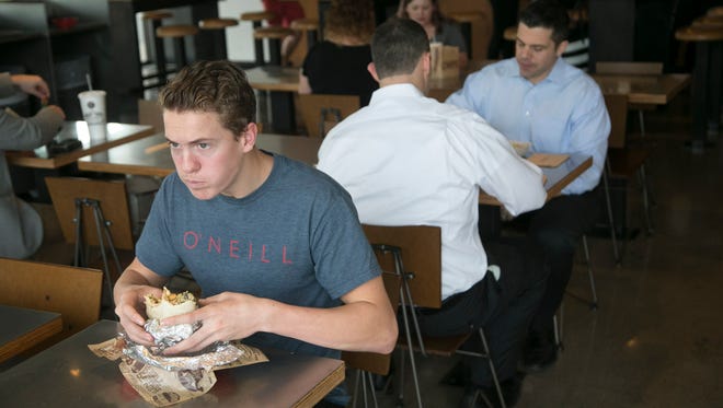 Marc Rigau, 17, eats a chicken burrito with all the fixings at a Chipotle Mexican Grill in Scottsdale on Thursday, Dec. 15, 2016.