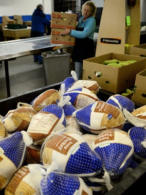 
Workers set up for food distribution at Paul's Pantry on Tuesday, November 18, 2014. 
