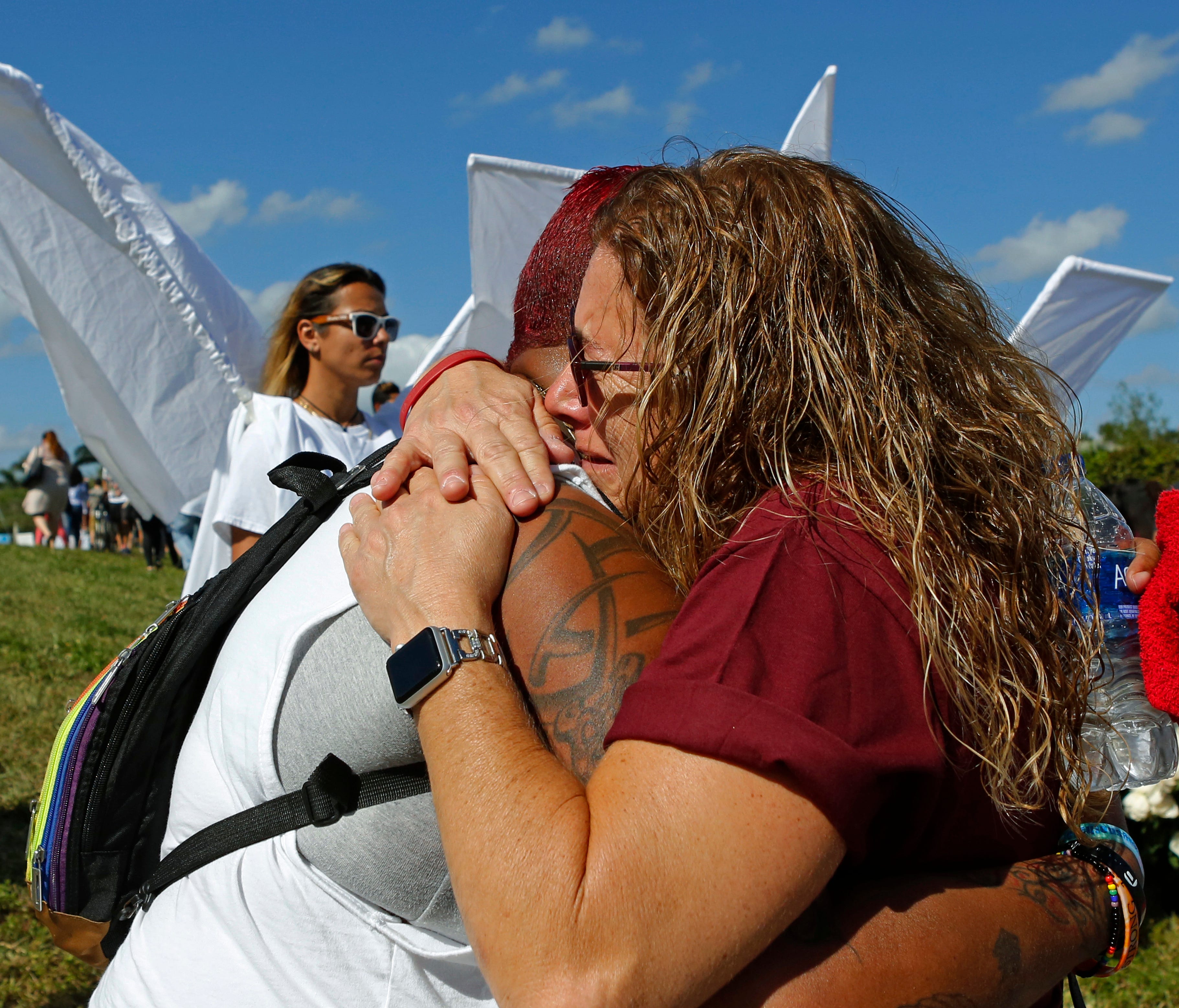 Pulse survivor India Godman, left, hugs Wendy Garrity at Marjory Stoneman Douglas High School in Parkland, Fla., Sunday, Feb. 25, 2018, for an open house as parents and students returned to the school for the first time since a shooting took place at
