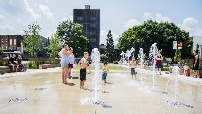 People stopped by the fountains at Elstro Plaza in downtown Richmond to beat the heat on June 18, 2018. The creation of the plaza was part of a makeover of the downtown area during the past decade.