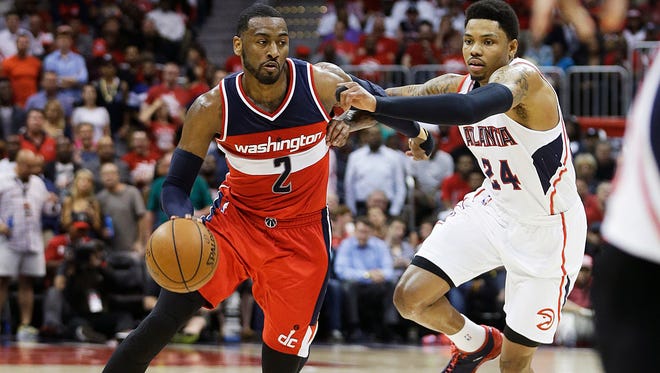 Washington Wizards' John Wall, left, dribbles against Atlanta Hawks' Kent Bazemore in the third quarter of Game 5 of the second round of the NBA basketball playoffs Wednesday, May 13, 2015, in Atlanta. (AP Photo/John Bazemore) 