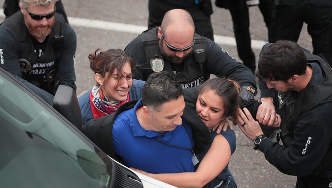 Manuel Duran with the Spanish-language news outlet Memphis Noticias is arrested with other protesters outside the Shelby County Justice Center during a demonstration to call attention to immigration issues Tuesday, April 3, 2018, in Memphis, Tenn.