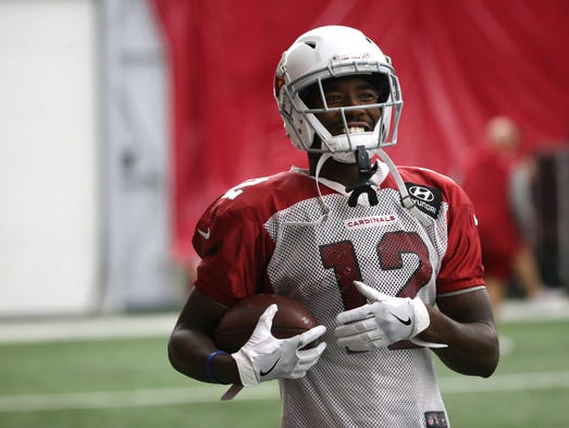 Cardinals John Brown (12) talks with teammates during