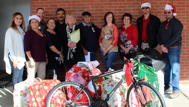Employees of White Sands Complex pose with some of the gifts they collected for economically disadvantaged children of  Las Cruces Public Schools. This is the 19th consecutive year the group has donated to children of the district.