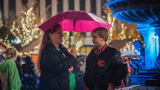 Stephanie and Ashton Brown stand under their umbrella during the drizzle on Fountain Square Friday evening. Hundreds made their way to Fountain Square November 27, 2015 to watch the Macy's Light Up the Square event.
