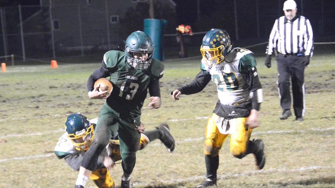 Cedarville quarterback Bailey Hilts turns the corner on the running play, while Carney-Nadeau's Michael Flanagan (20) pursues during Thursday's playoff game. The Trojans won 38-6 and will have another home playoff game next week against Rapid River.