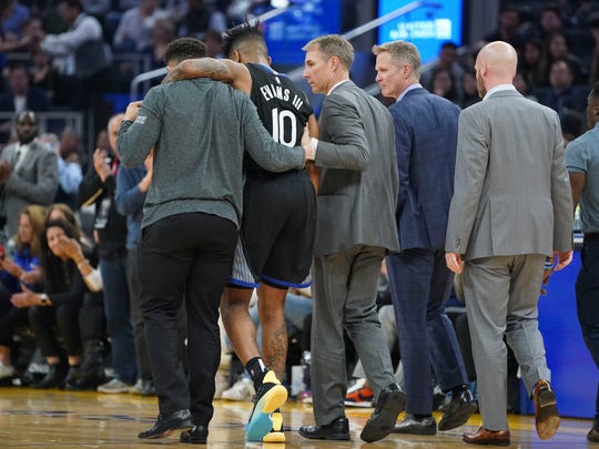 January 14, 2020; San Francisco, California, USA; Golden State Warriors guard Jacob Evans (10) is helped off the court after an injury against the Dallas Mavericks during the second quarter at Chase Center. Mandatory Credit: Kyle Terada-USA TODAY Sports