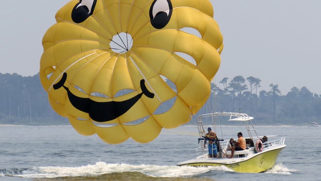 
Key Sailing employees prepare to take customers parasailing on the Santa Rosa Sound off of Quietwater Beach in 2012. A new law governing the operation of parasailing companies goes into effect today.
