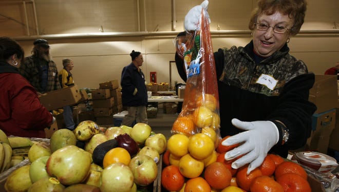 Helen Christensen sorts fruit during the Faith Temple Food Giveaway at the W.H. Lyon Fairgrounds in Sioux Falls, S.D., Friday, Dec. 16, 2011.
