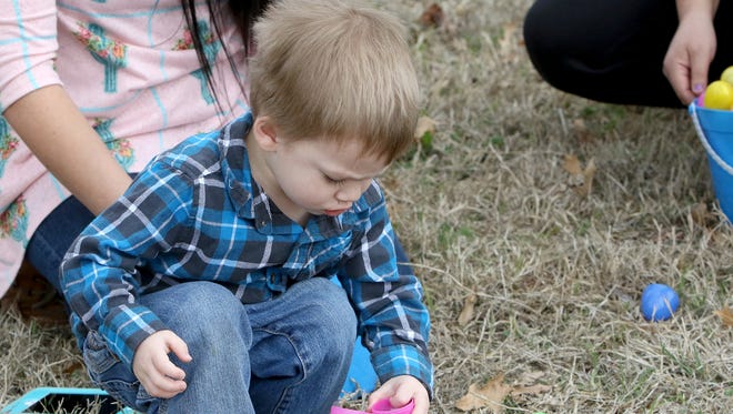 Jaxton Ballard looks inside a plastic egg Saturday, March 17, 2018, at the Wichita Falls Parks and Recreation Annual Easter Egg Hunt in Lucy Park.