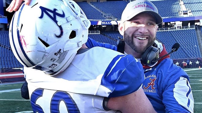 Ashland's Ryan Dwinnells (left) embraces coach Andrew MacKay after the Clockers won the Division 6 Super Bowl title at Gillette Stadium in 2019.