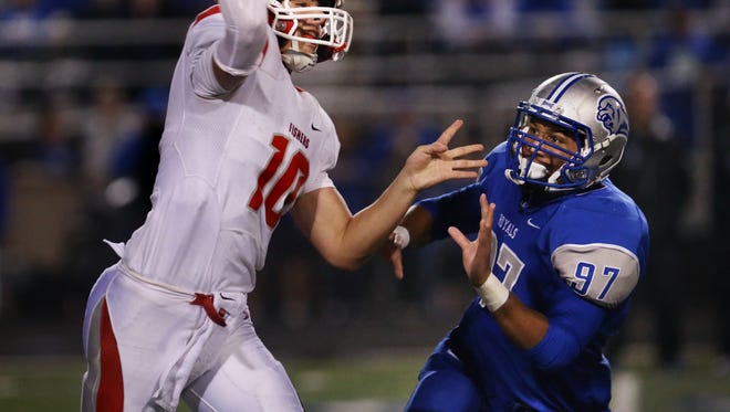 HSE Royals linebacker Collin Miller pressures Fishers Tigers quarterback Zach Eaton as he passes deep in Hamilton Southeastern territory in the fourth quarter, en route to the Tigers' 41-10 win over the Royals at HSE on Friday, September 12, 2014.