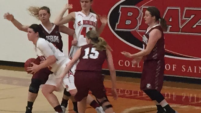 St. Benedict junior Macy Kelly attempts to get the ball out of traffic as teammate Niki Fokken looks on in the Blazers' 42-37 win over Augsburg Saturday afternoon at Claire Lynch Hall.