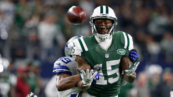 New York Jets wide receiver Brandon Marshall (15) misses a catch and is tackled by Dallas Cowboys cornerback Brandon Carr (39) during the first half of an NFL football game Saturday,