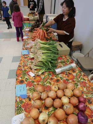 A vendor rearranges her carrots at the Winter Farmers Market in Wausau. This year, the market will be held at 130 First Street on Saturday mornings from November to April.