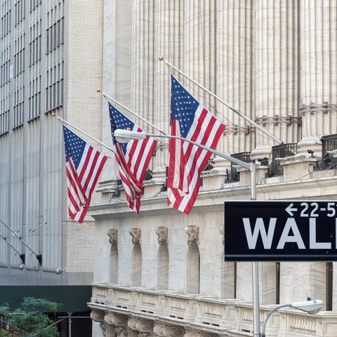 Wall Street street sign in front of a building wit
